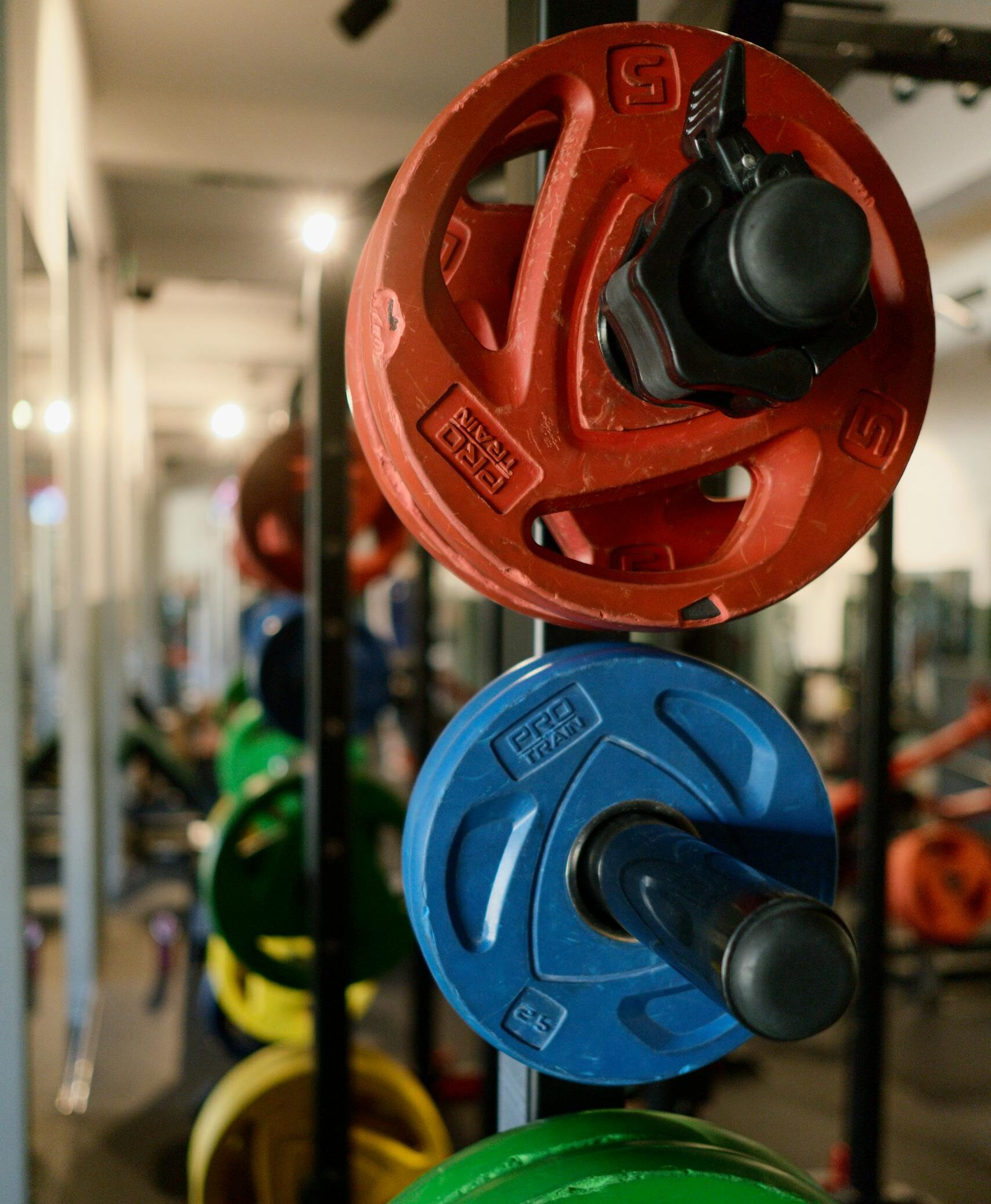 Stack of colorful weight plates in a modern gym, perfect for fitness enthusiasts.